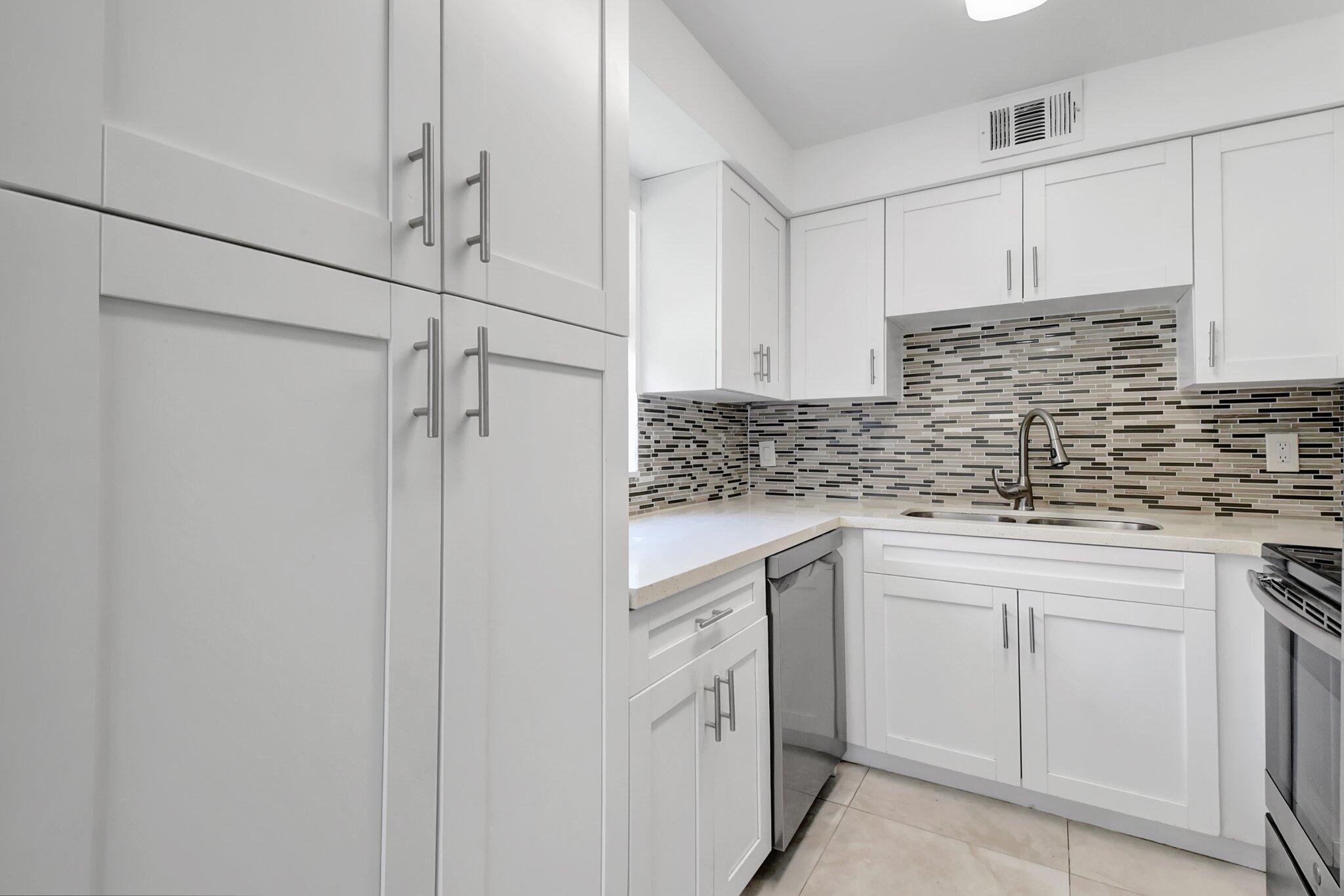 21 Brittany F, Unit A Delray Beach, FL 33446 - Photo 2 of 41 a kitchen with white cabinets and white appliances