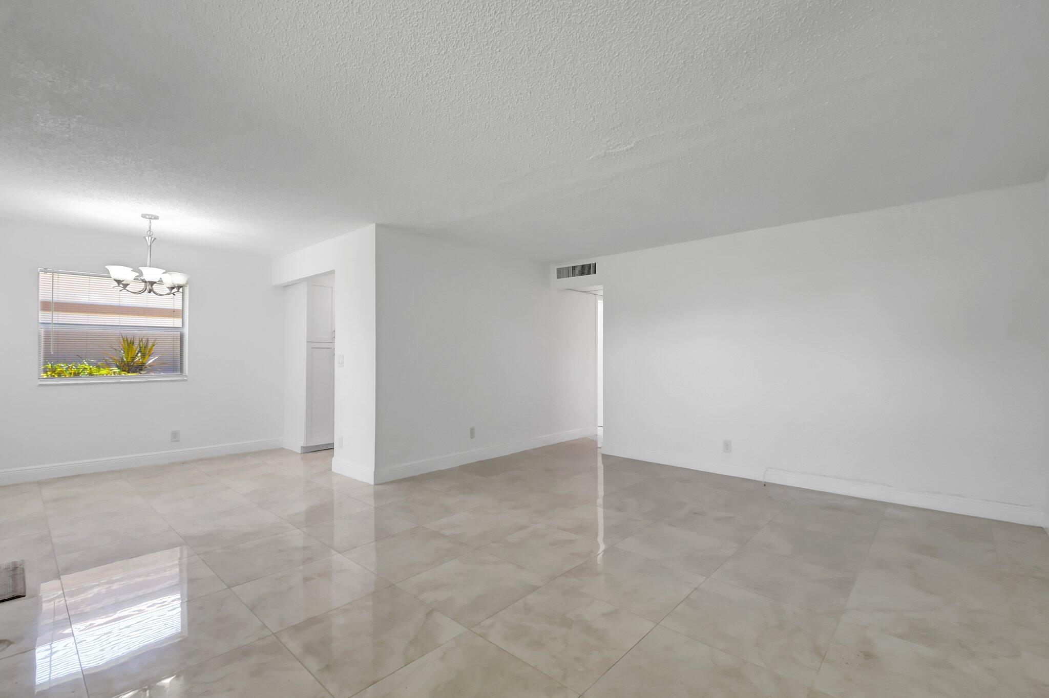 21 Brittany F, Unit A Delray Beach, FL 33446 - Photo 4 of 41 an empty room with a mirror and a window