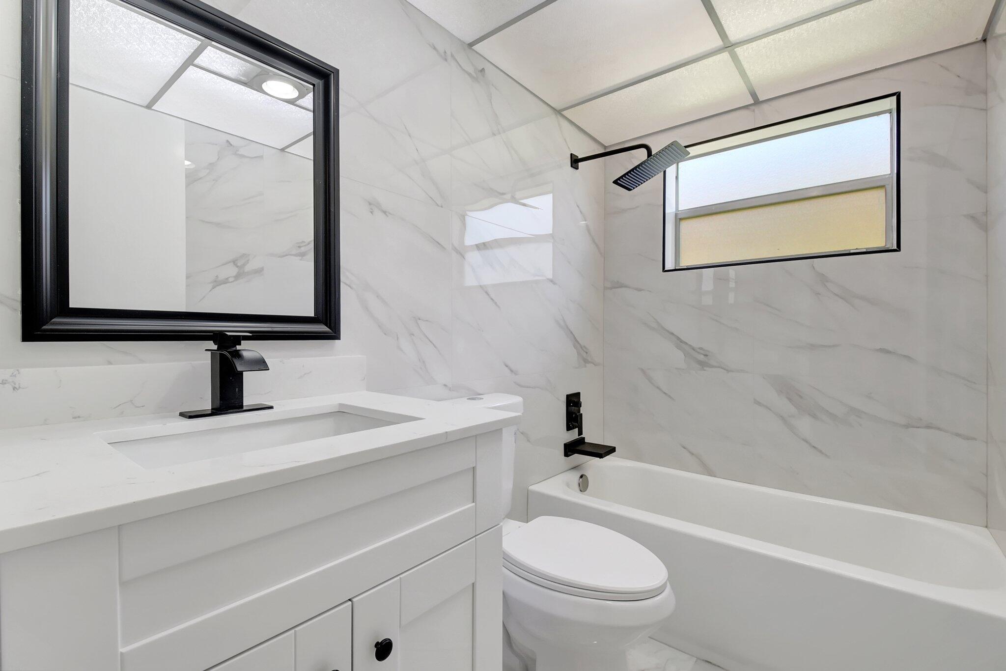 21 Brittany F, Unit A Delray Beach, FL 33446 - Photo 8 of 41 a bathroom with a sink a toilet and a bathtub