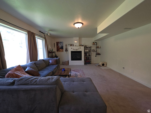 387 North Loafer Canyon Road Payson, UT 84651 - Photo 50 of 94 Spacious living area featuring a built-in fireplace with a white mantel, large windows, recessed ceiling beams, and light-toned carpet flooring