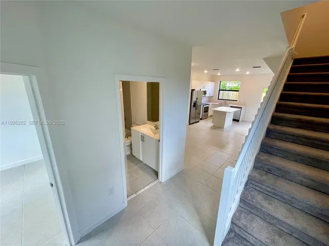 a view of a living room with furniture and stairs