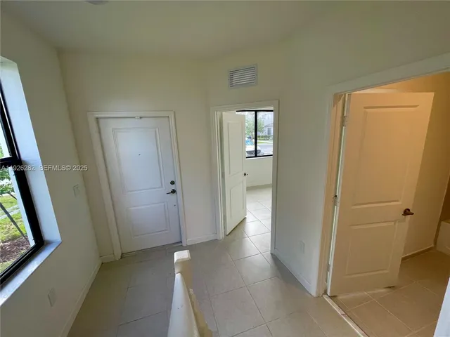 a view of a hallway with wooden floor and closet