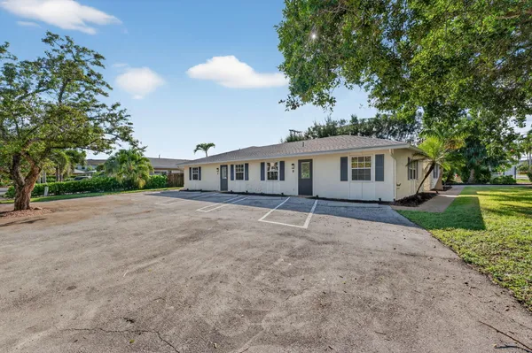 a dining room with wooden floor a chandelier a wooden table and chairs
