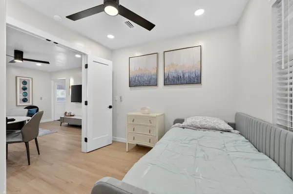 a spacious bedroom with a bed a chandelier and a window