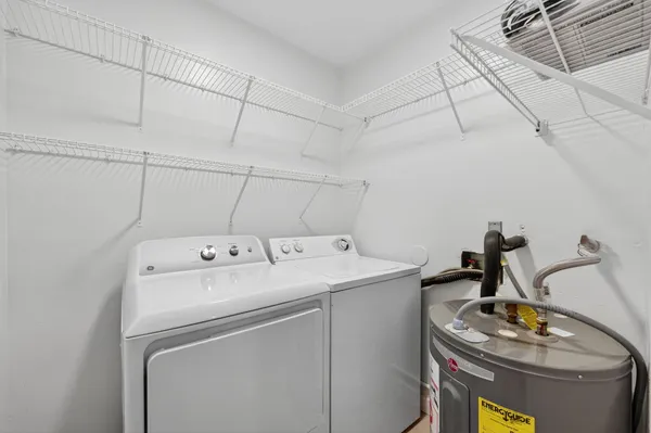 a kitchen with stainless steel appliances granite countertop a refrigerator a sink dishwasher a stove and a dining table with wooden floor