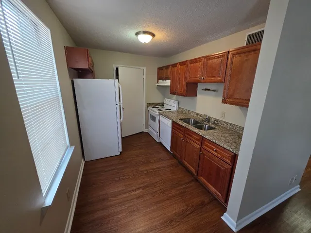 a kitchen with stainless steel appliances granite countertop refrigerator a sink and wooden cabinets