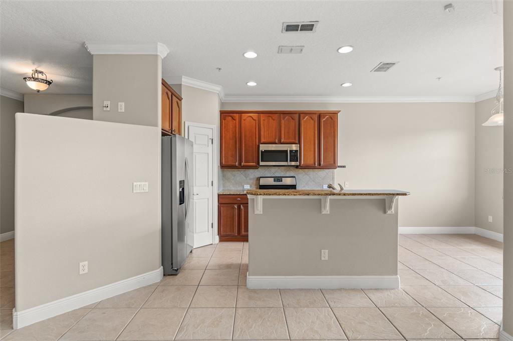 868 Assembly Court Reunion, FL 34747 - Photo 11 of 43 a view of kitchen with stainless steel appliances a refrigerator and a stove top oven