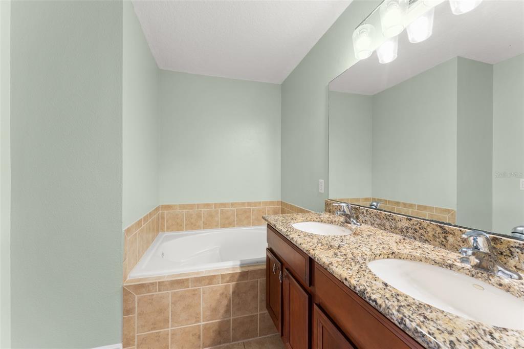 868 Assembly Court Reunion, FL 34747 - Photo 27 of 43 a bathroom with a granite countertop sink and a mirror