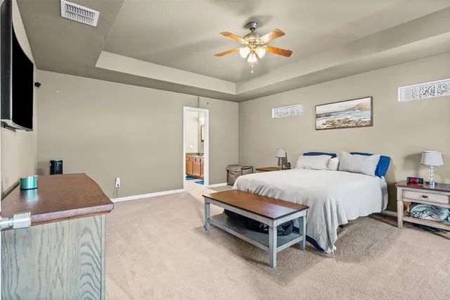a spacious bedroom with a bed and a computer on the desk