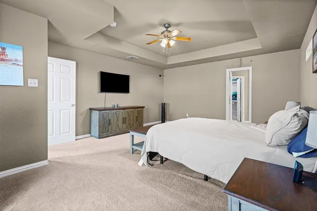 a spacious bedroom with a bed and a flat screen tv