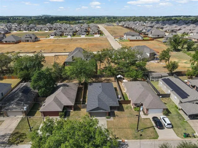 an aerial view of residential houses with outdoor space and ocean