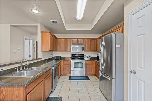 a kitchen with stainless steel appliances granite countertop a sink stove and refrigerator