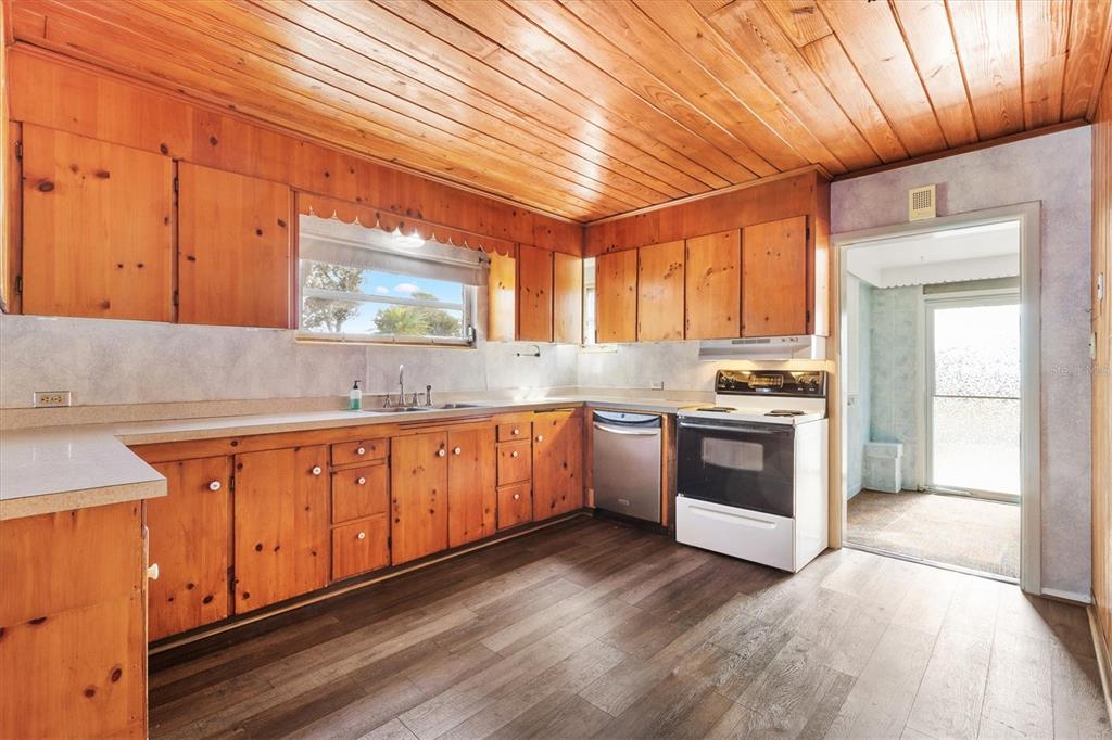 5605 Berts Road Lady Lake, FL 32159 - Photo 11 of 38 a kitchen with granite countertop white cabinets and white appliances