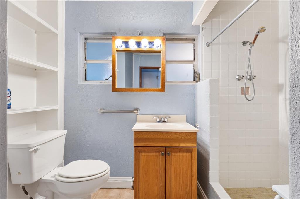 5605 Berts Road Lady Lake, FL 32159 - Photo 17 of 38 a bathroom with a toilet sink vanity and mirror
