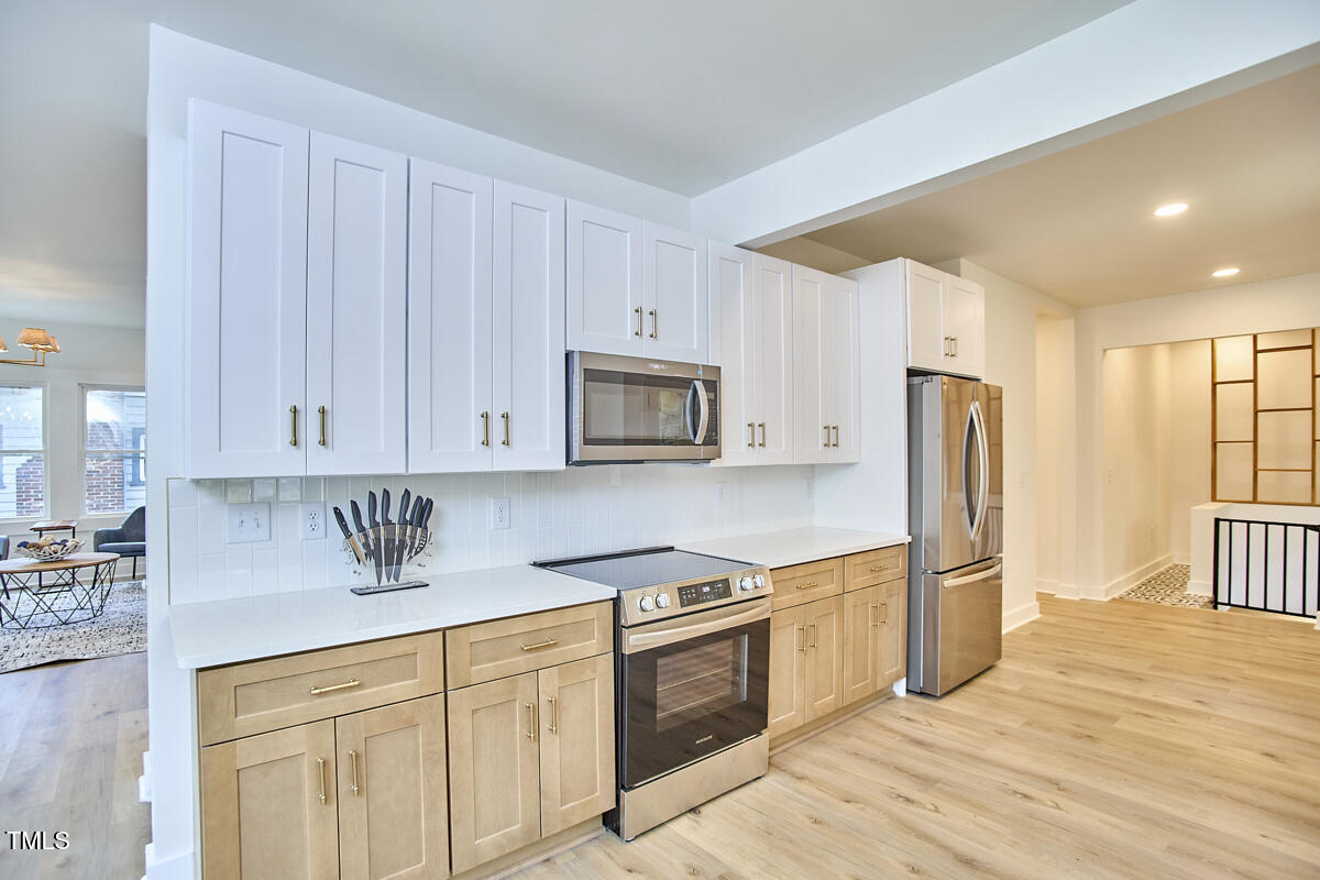 2203 University Drive Durham, NC 27707 - Photo 11 of 40 a kitchen with stainless steel appliances granite countertop a refrigerator sink and white cabinets