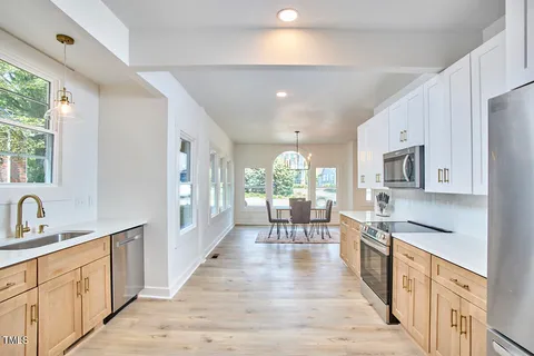 a large kitchen with stainless steel appliances lots of counter space and a sink
