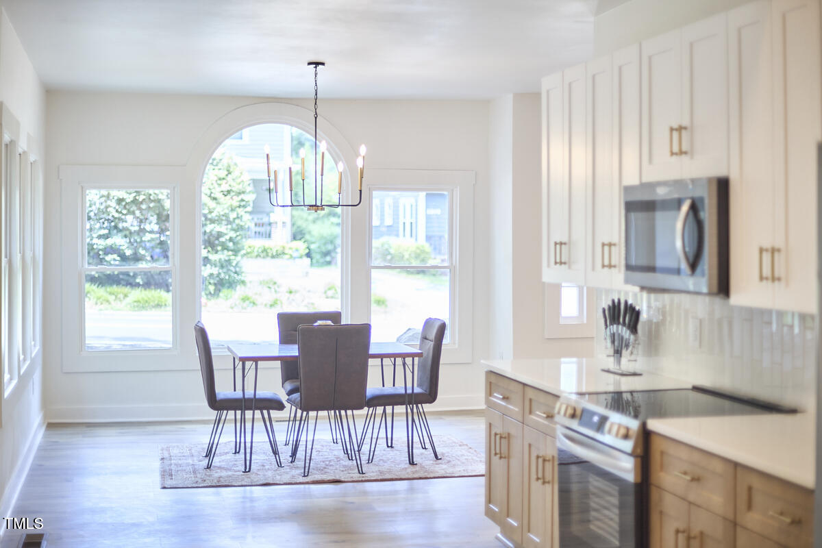 2203 University Drive Durham, NC 27707 - Photo 13 of 40 a dining room with furniture a chandelier and wooden floor