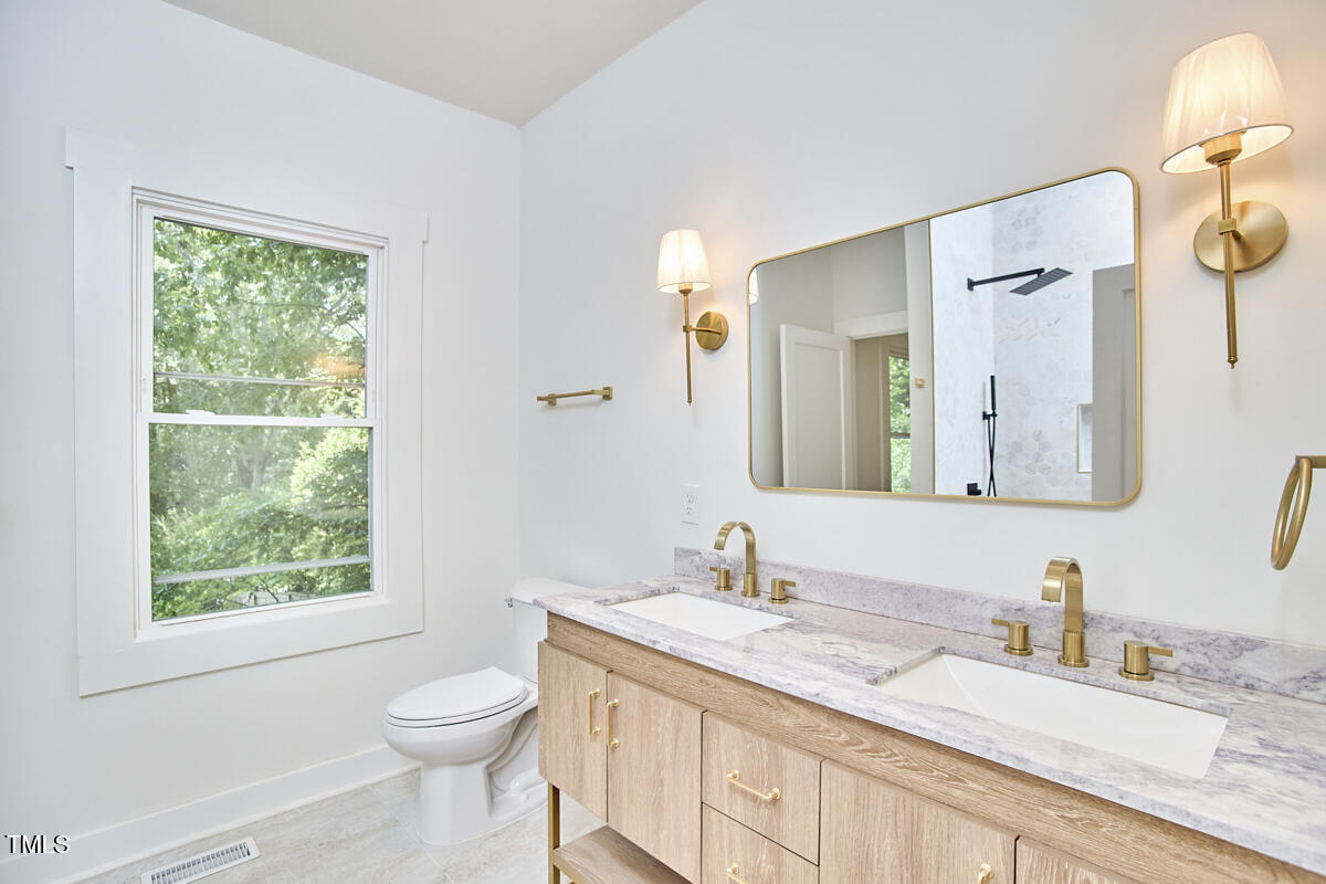 2203 University Drive Durham, NC 27707 - Photo 16 of 40 a bathroom with a granite countertop sink toilet and mirror