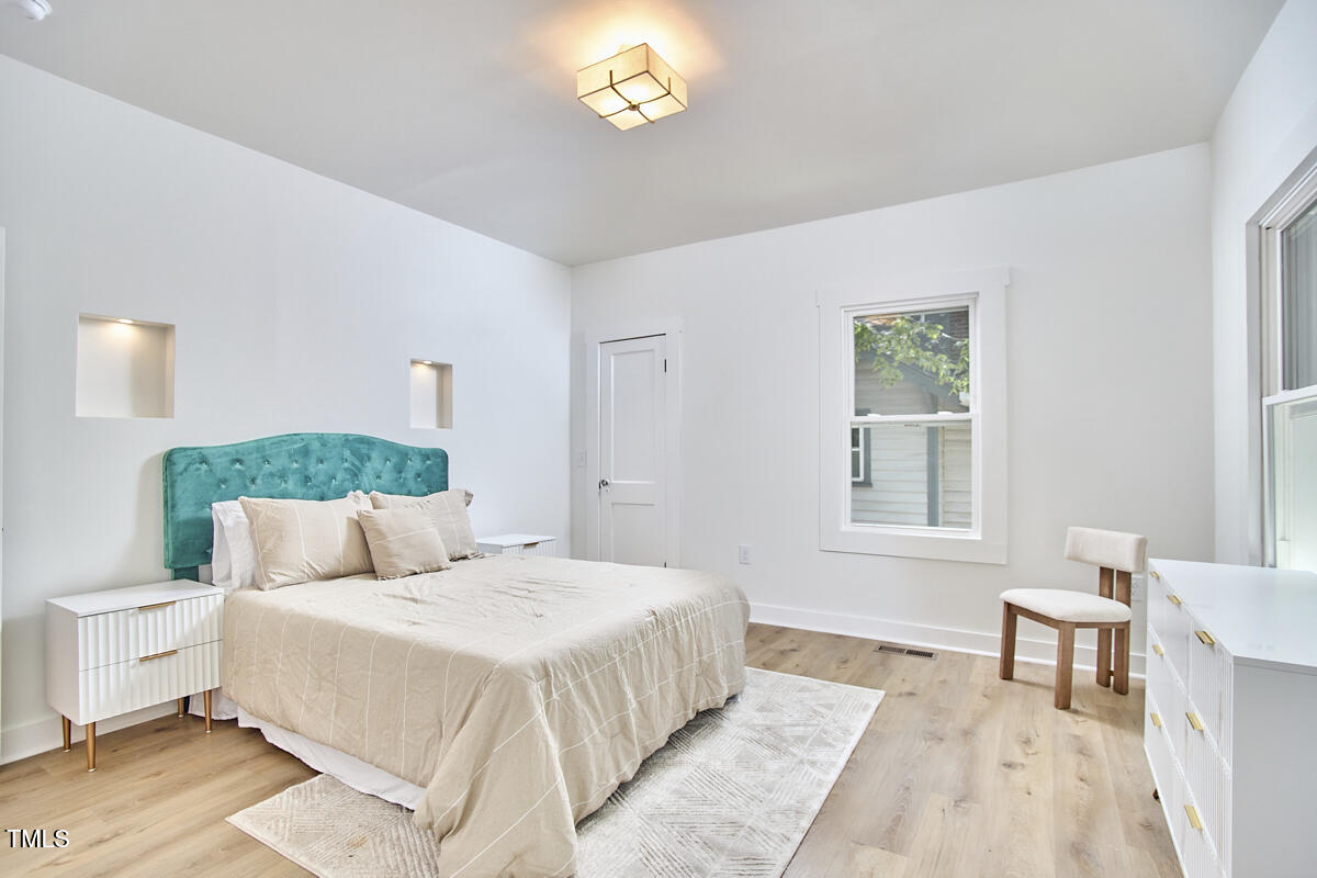 2203 University Drive Durham, NC 27707 - Photo 18 of 40 a bedroom with a bed and a table lamp on dresser