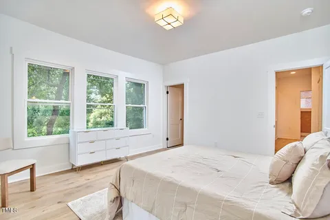 a bed sitting in a bedroom next to a window