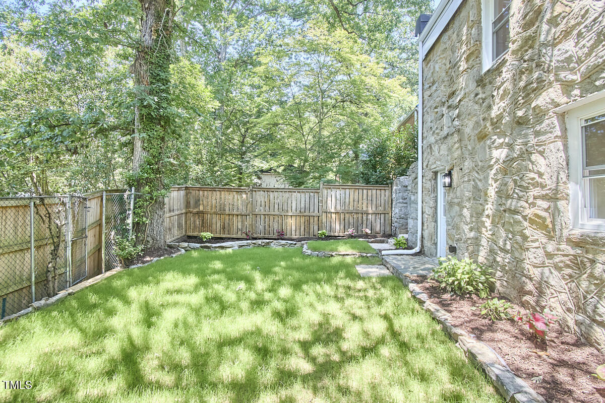 2203 University Drive Durham, NC 27707 - Photo 29 of 40 a view of a backyard with large trees and wooden fence