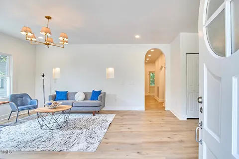 a living room with furniture and a chandelier