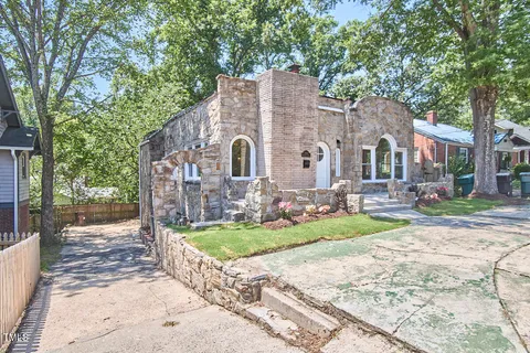 a view of a house with a yard and pathway