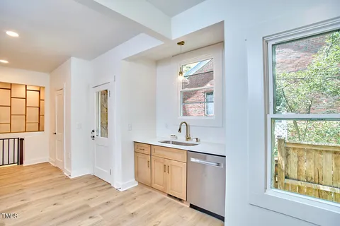 a kitchen with a sink cabinets appliances and a window