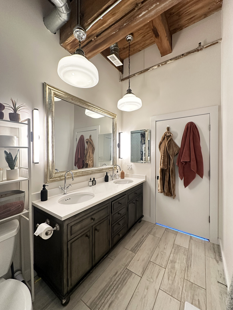1330 West Monroe Street, Unit 311 Chicago, IL 60607 - Photo 13 of 16 a spacious bathroom with a double vanity sink a mirror and a toilet