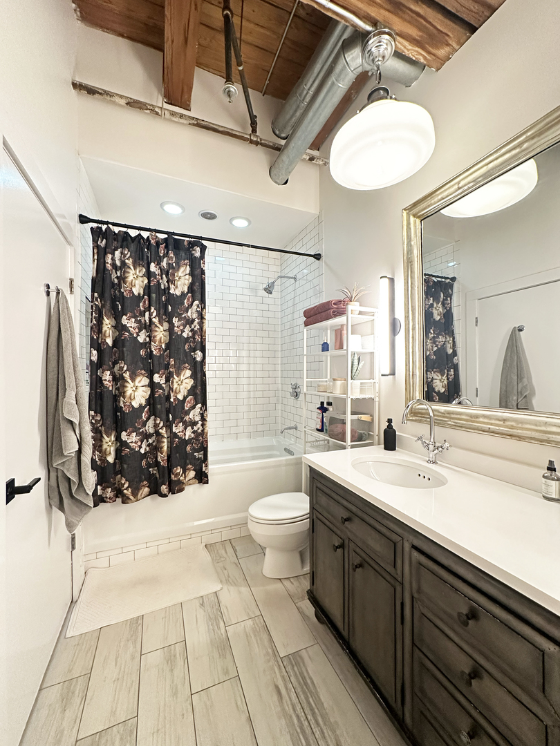 1330 West Monroe Street, Unit 311 Chicago, IL 60607 - Photo 14 of 16 a spacious bathroom with a double vanity sink toilet mirror and shower