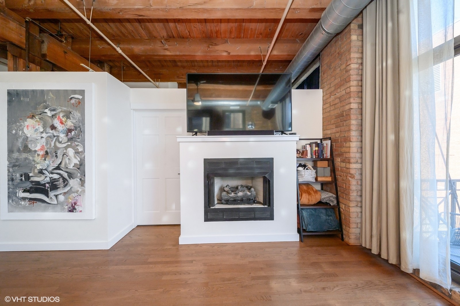 1330 West Monroe Street, Unit 311 Chicago, IL 60607 - Photo 4 of 16 a living room with furniture and a fireplace