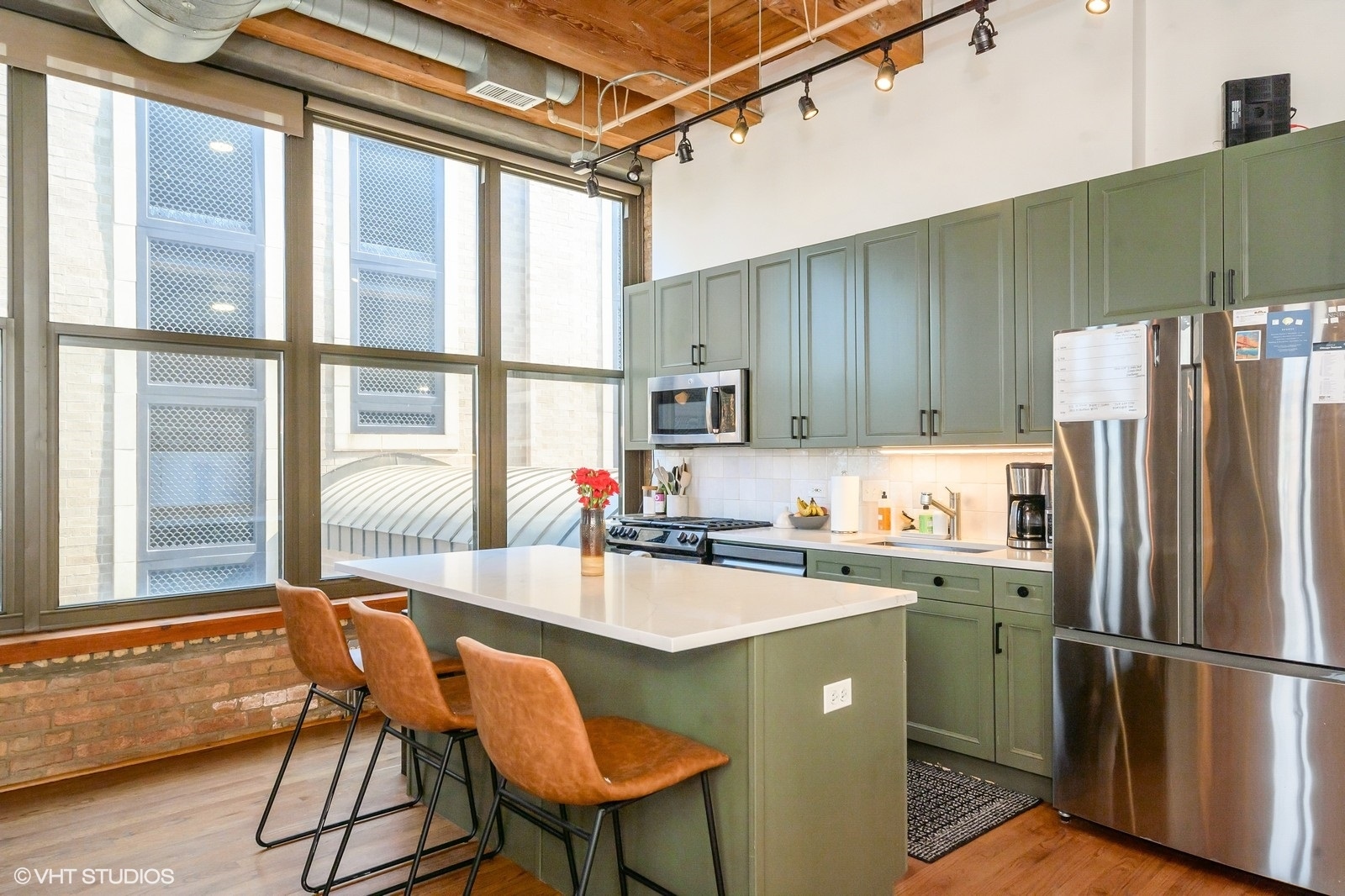 1330 West Monroe Street, Unit 311 Chicago, IL 60607 - Photo 5 of 16 a kitchen with a table chairs refrigerator and cabinets