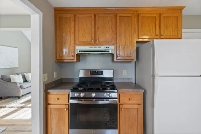 a kitchen with stainless steel appliances granite countertop a stove a refrigerator and a cabinet