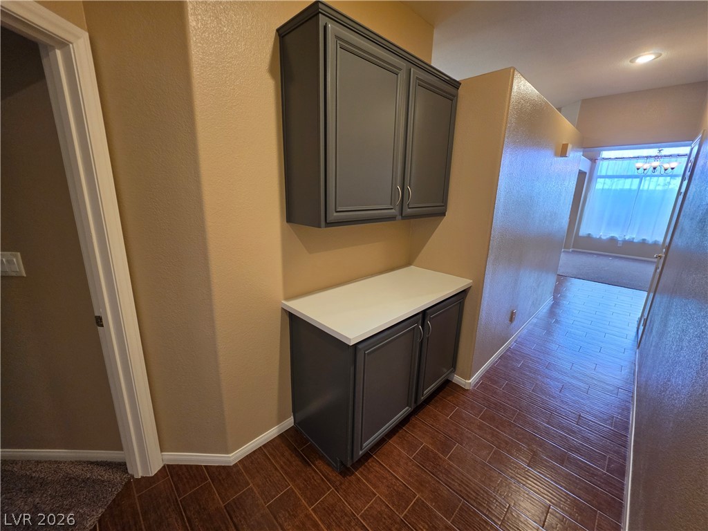 209 Opera House Street Henderson, NV 89012 - Photo 18 of 45 Gleaming wood-look tile floors guide guests past built-in cabinetry into the main living areas.