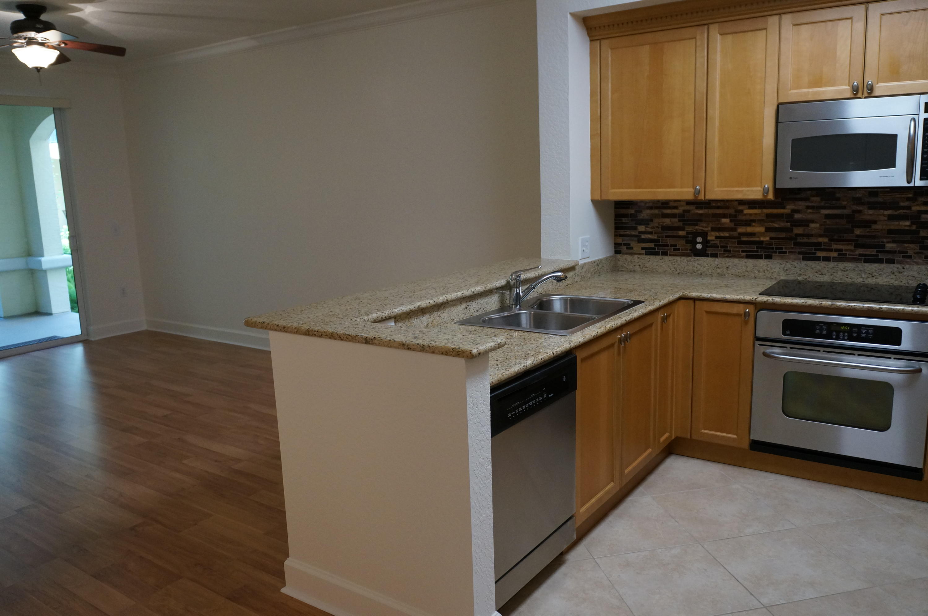 1121 Renaissance Way, Unit 121 Boynton Beach, FL 33426 - Photo 17 of 28 a kitchen with granite countertop a sink stove and microwave