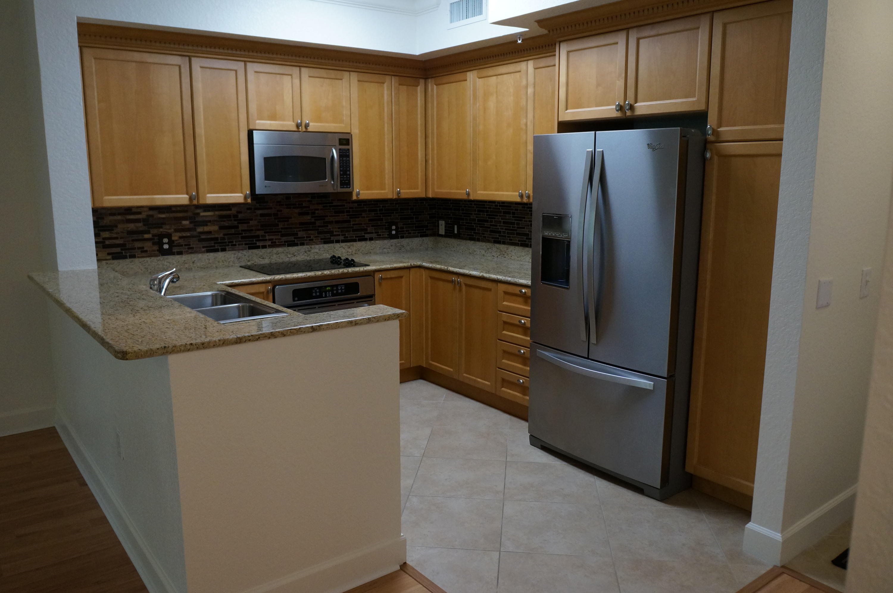 1121 Renaissance Way, Unit 121 Boynton Beach, FL 33426 - Photo 3 of 28 a kitchen with metallic refrigerator and microwave