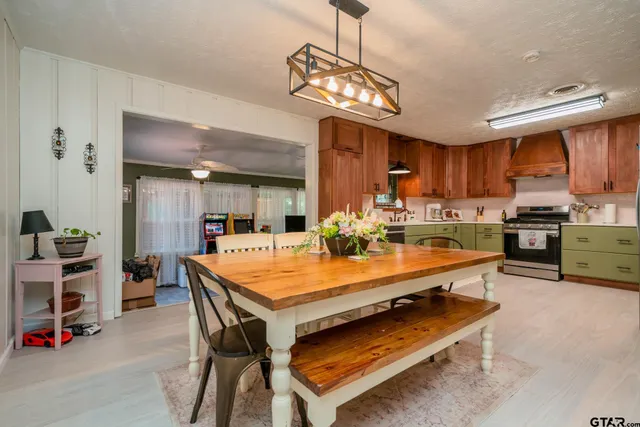 a room with stainless steel appliances kitchen island a table and chairs in it