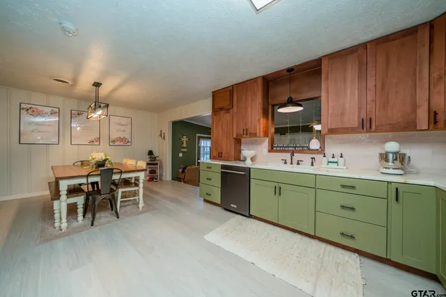 a kitchen with cabinets a sink and chairs