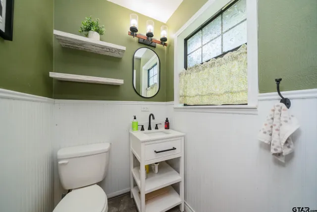 a bathroom with a toilet sink and mirror