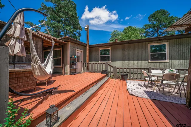 a backyard of a house with wooden floor potted plants and outdoor seating