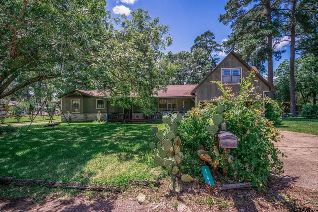 a front view of a house with a yard and tree