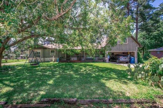a front view of a house with yard and tree