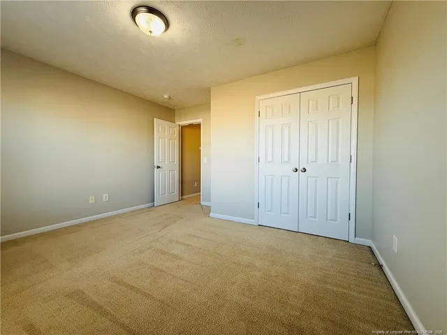 an empty room with windows and closet