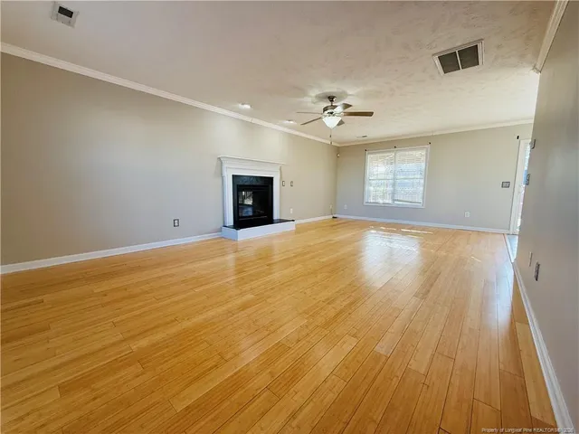 a view of an empty room with a fireplace and a window