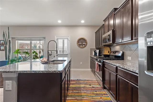 a large kitchen with granite countertop a stove and a sink