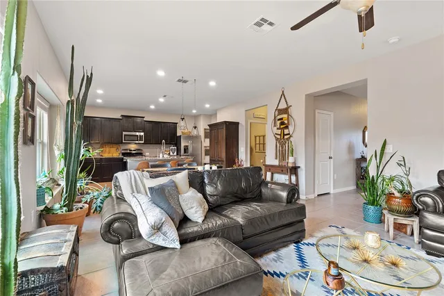 a living room with furniture and a view of kitchen