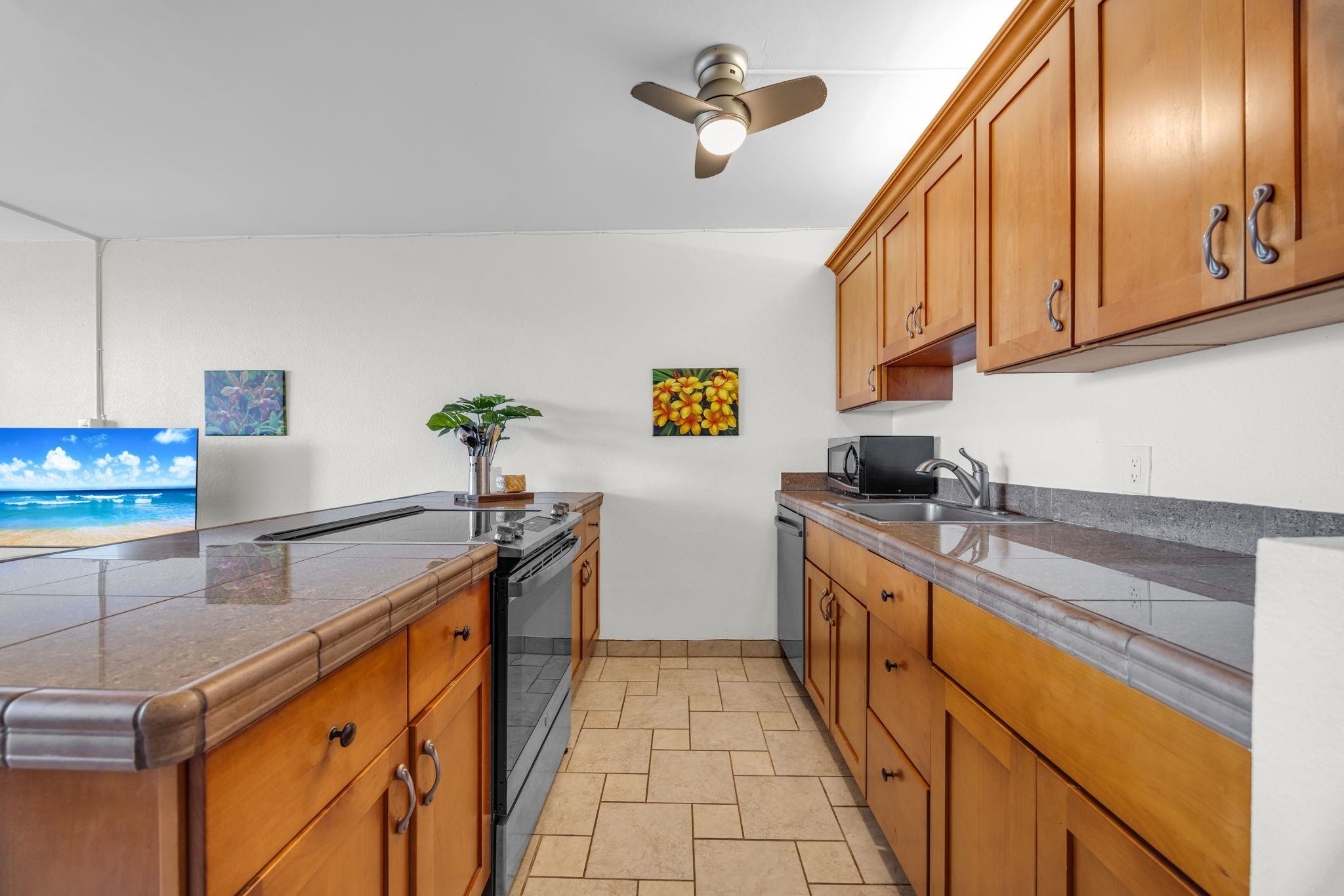 2191 South Kihei Road, Unit 2306 Kihei, HI 96753 - Photo 12 of 41 a kitchen with stainless steel appliances granite countertop a sink a stove top oven a chimney and a center island