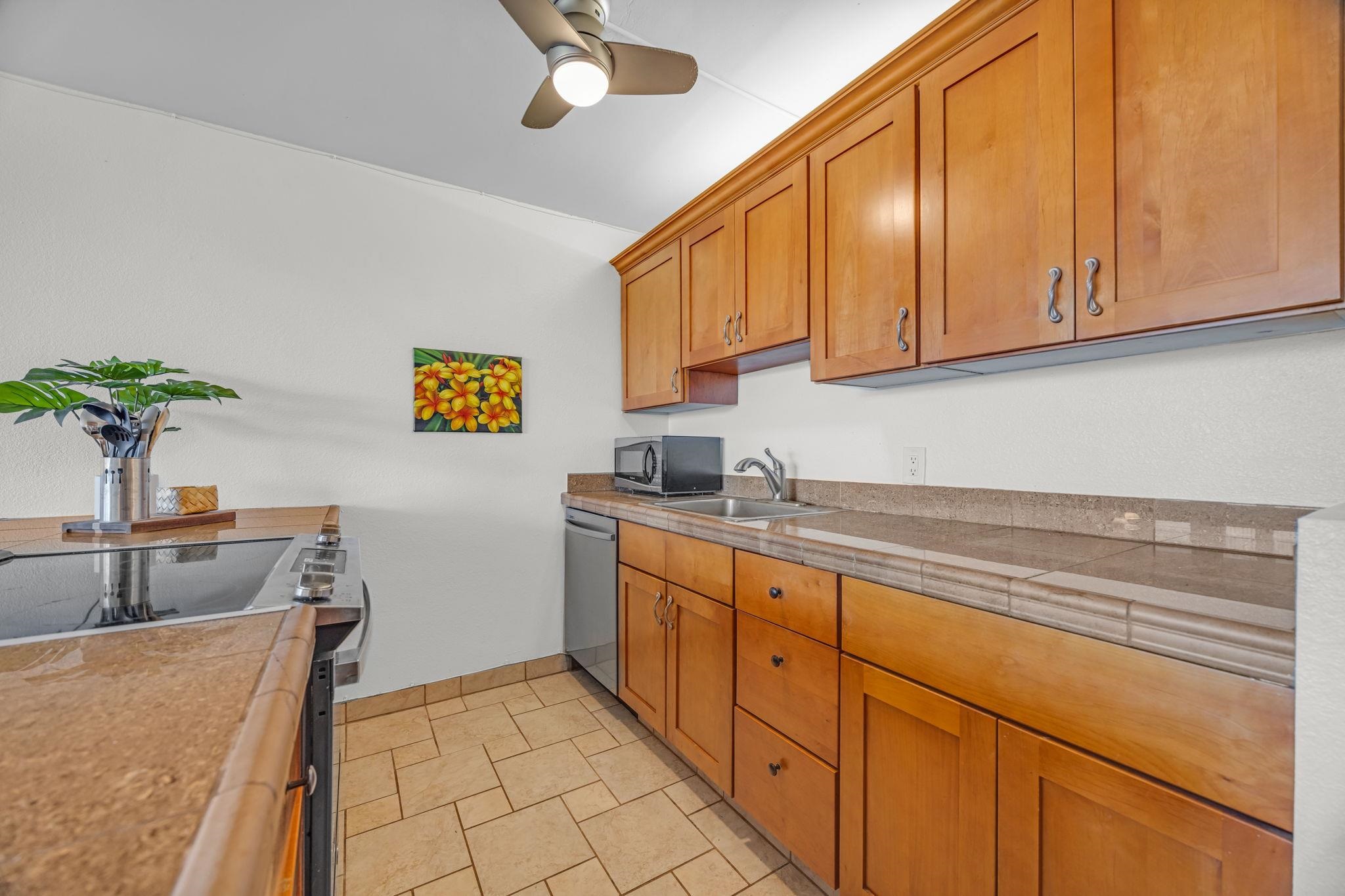2191 South Kihei Road, Unit 2306 Kihei, HI 96753 - Photo 14 of 41 a kitchen with stainless steel appliances granite countertop a sink a stove cabinets dining table and chairs