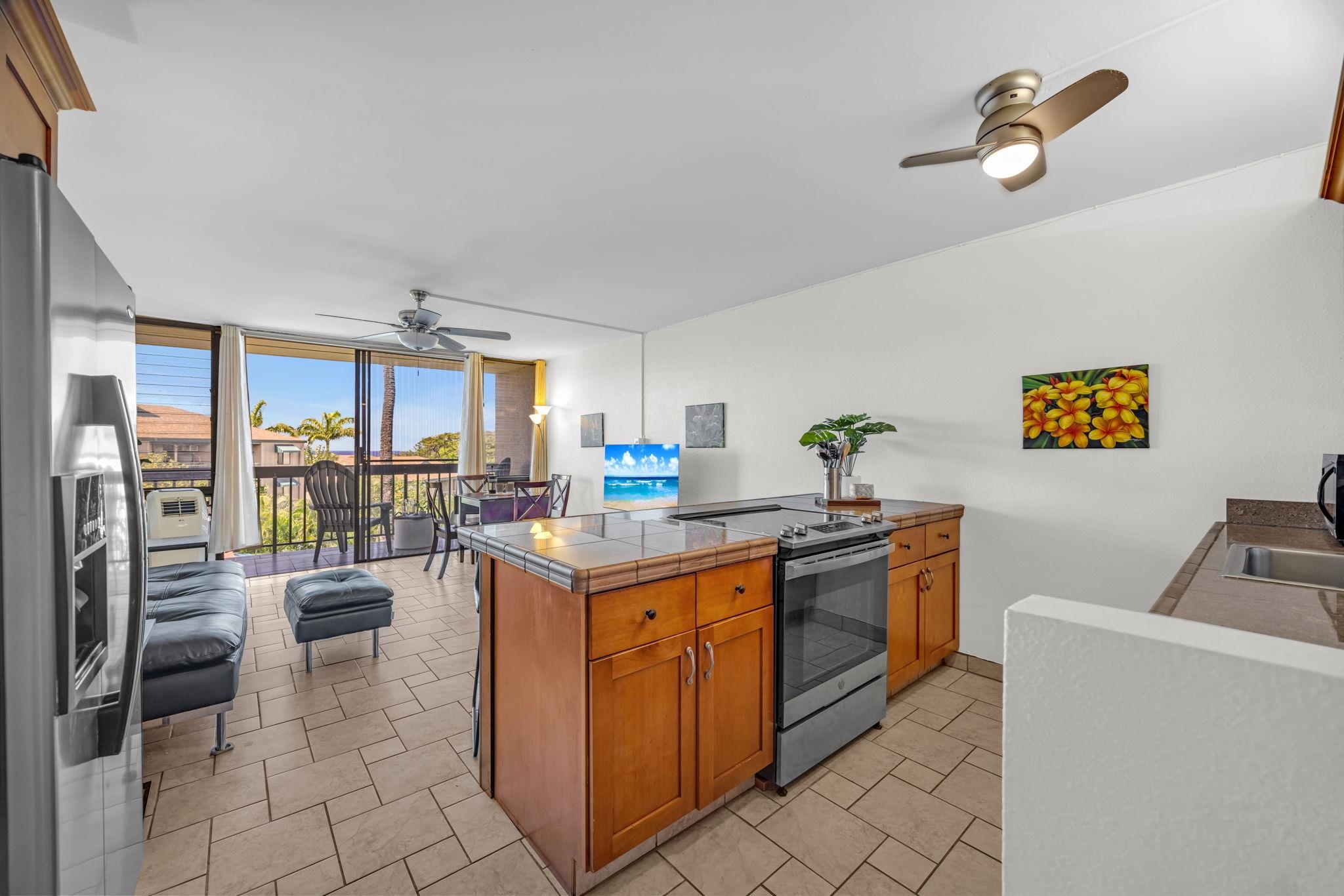 2191 South Kihei Road, Unit 2306 Kihei, HI 96753 - Photo 16 of 41 a kitchen with kitchen island a stove a sink a oven with a dining table and chairs