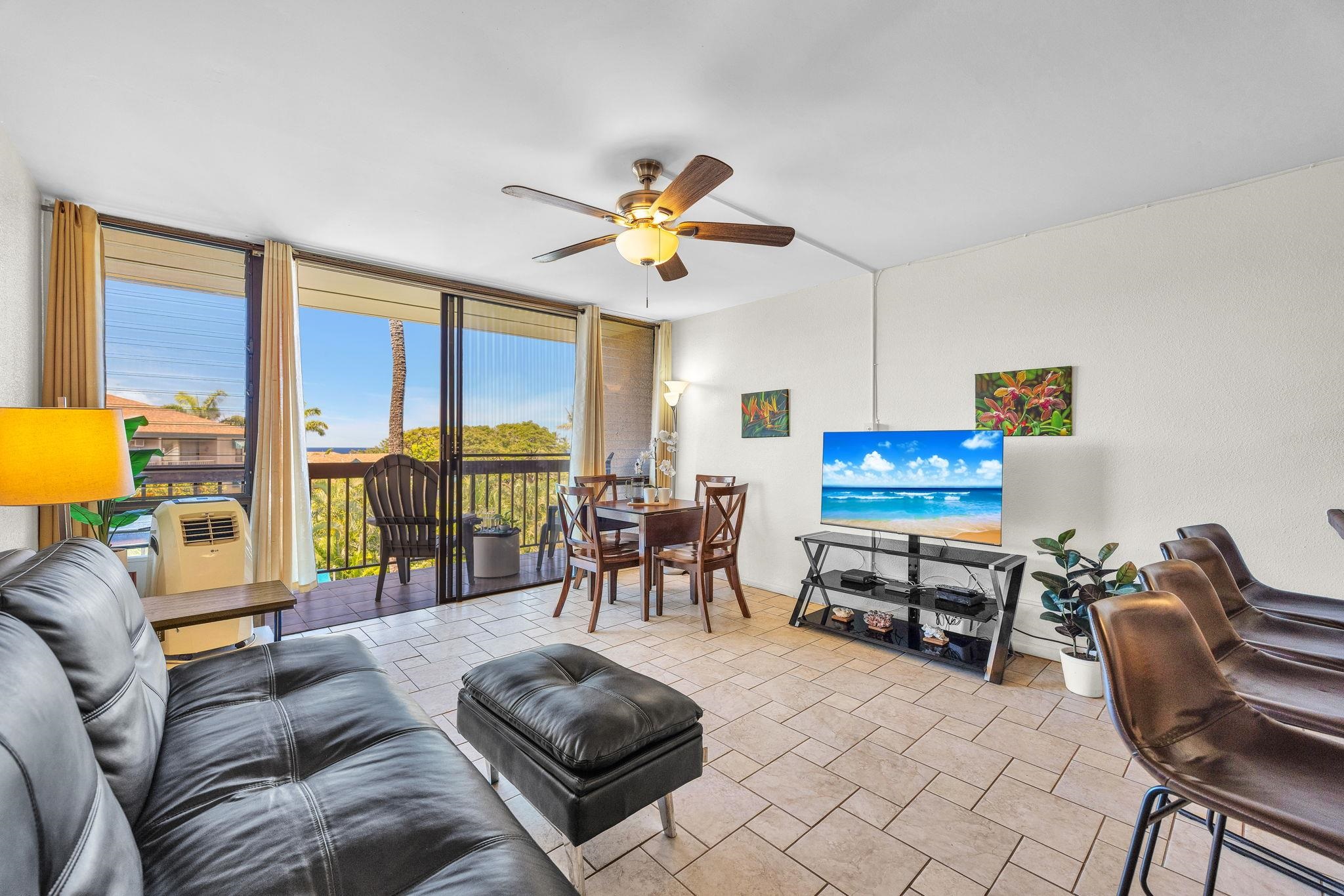 2191 South Kihei Road, Unit 2306 Kihei, HI 96753 - Photo 4 of 41 a living room with furniture a flat screen tv and a large window with rug view